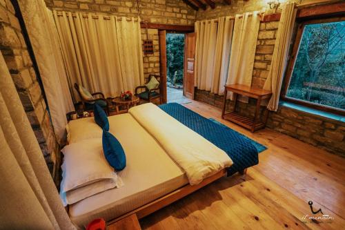 a bedroom with a large bed in a log cabin at Itmenaan Estate in the Himalayas in Almora