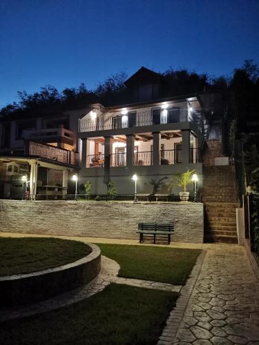 a large building with a bench in front of it at night at Casa Dorin in Orşova