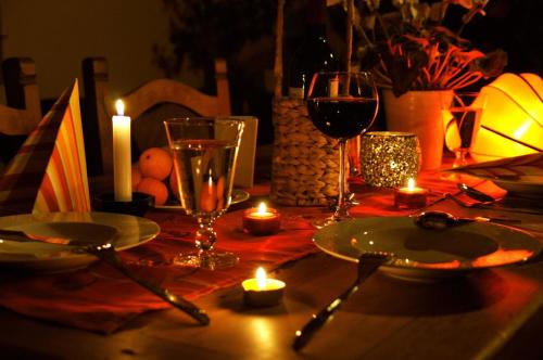 a table with candles and wine glasses on a table with a table at Itmenaan Estate in the Himalayas in Almora