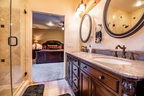 a bathroom with a sink and a mirror and a bed at Luxury Cabin-Walk to Bear Mountain Resort, Trails & Golf in Big Bear Lake