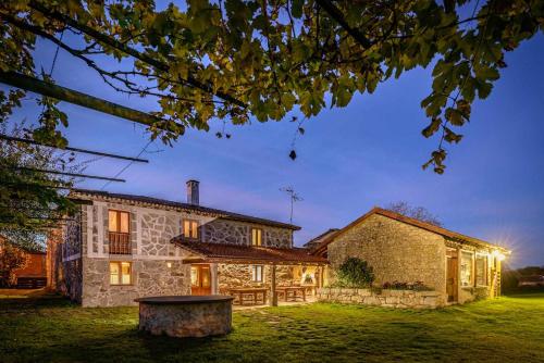 an exterior view of a stone house at night at Casa das xacias ribeira sacra in A Airoa