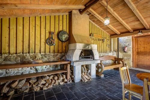 a room with a stone fireplace in a wooden house at Casa das xacias ribeira sacra in A Airoa