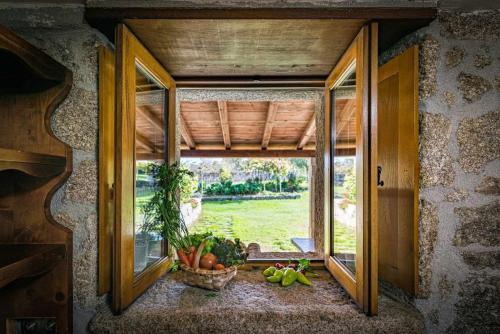 a window in a room with a bunch of fruits and vegetables at Casa das xacias ribeira sacra in A Airoa