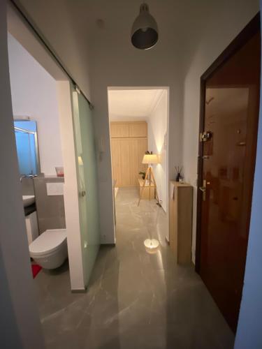 ein Bad mit einem WC, einem Waschbecken und einer Tür in der Unterkunft Cosy 2 pièces, résidence en front de mer, Roquebrune Cap Martin in Roquebrune-Cap-Martin