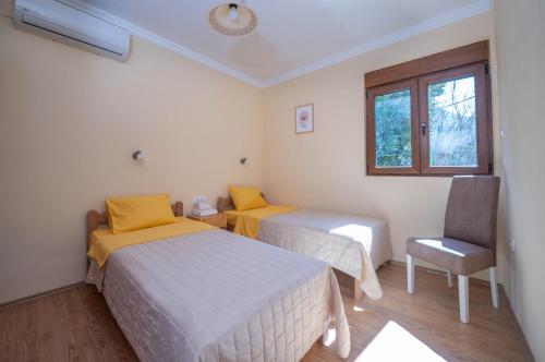 una camera con due letti e una sedia e una finestra di Apartment Vento di Bocche II a Kotor (Cattaro)