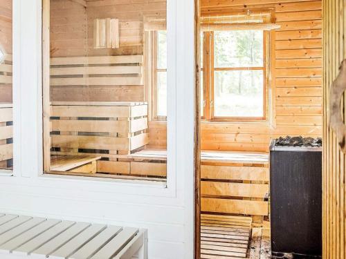 FlenにあるHoliday home FLEN Vの木製の壁、コンロ、窓が備わる客室です。