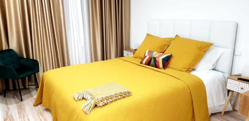 a bedroom with a yellow bed and a chair at Aroma d in Orca