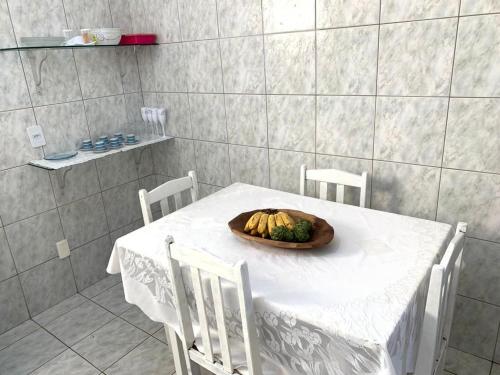 a white table with a bowl of food on it at Apartamento charmoso próximo ao Centro in Vitória da Conquista