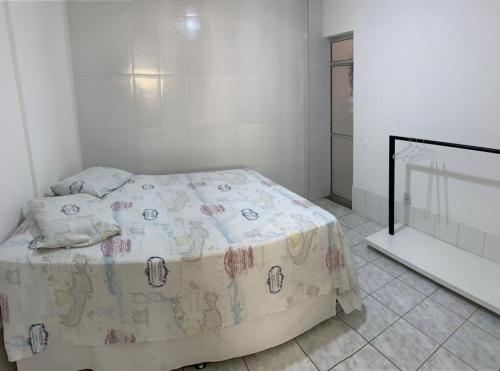 um quarto com uma cama com um cobertor em Apartamento charmoso próximo ao Centro em Vitória da Conquista