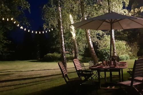 a table with an umbrella and chairs in a yard at Au Clos Caleste in Wellin
