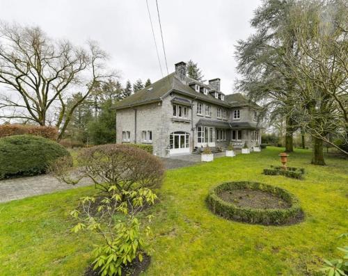 a large white house with a garden in the yard at Au Clos Caleste in Wellin