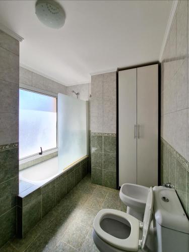 a bathroom with a white toilet and a window at Departamento Nueva Córdoba RW in Córdoba
