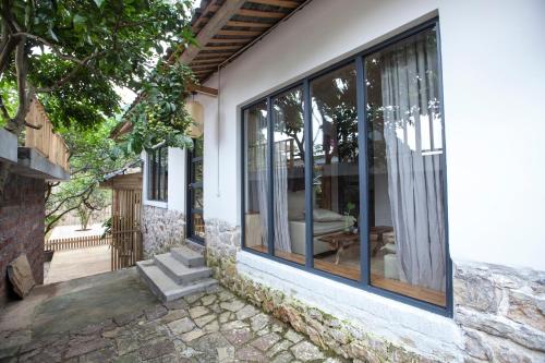 a house with large glass windows and a patio at Zen Box House in Yangshuo