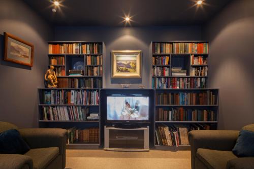 a living room with two large book shelves filled with books at Matuka Lodge in Twizel