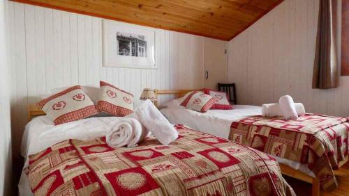 two beds in a room with red and white blankets at Chalet Falcon With Hot Tub - in a great location! in Chamonix-Mont-Blanc