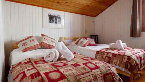 two beds in a room with red and white blankets at Chalet Falcon With Hot Tub in Chamonix-Mont-Blanc