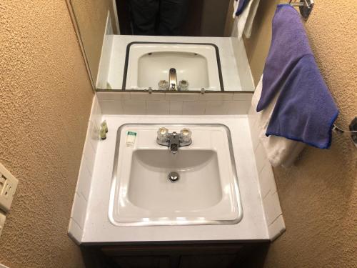 a white sink in a bathroom with a blue towel at High Country Lodge in Alto