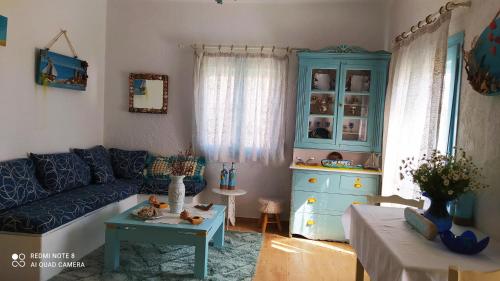 ein Wohnzimmer mit einem blauen Sofa und einem blauen Schrank in der Unterkunft Socrates sea view in Kámpos