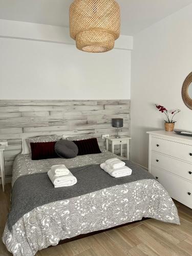 a bedroom with a bed with two towels on it at Apartamentos La Higuera 1 in Rota