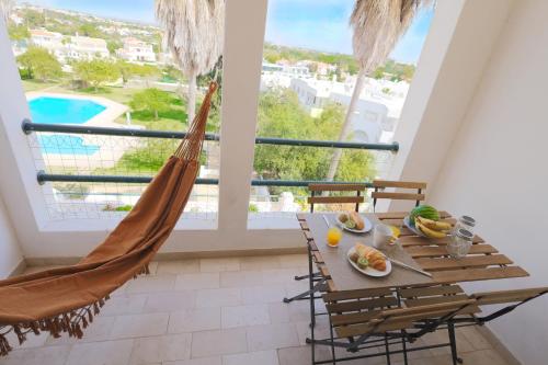 a room with a hammock and a table with fruit on it at Apartamentos Ninho das Gaivotas in Albufeira