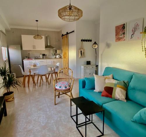 a living room with a blue couch and a kitchen at Casa Ninive in Fuencaliente de la Palma