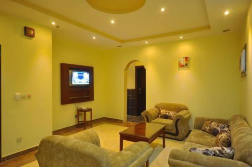 - un salon avec deux canapés et une télévision dans l'établissement Kinda Suites, à Taif