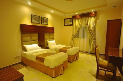 une chambre d'hôtel avec deux lits et un piano dans l'établissement Kinda Suites, à Taif