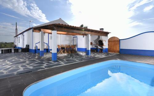 a villa with a swimming pool and a house at Montinho Do Cerro Alto in Cercal