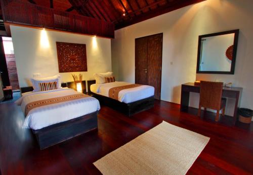 a bedroom with two beds and a mirror at Villa Samudra Luxury Beachfront in Ketewel