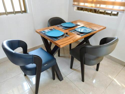 mesa de comedor con 4 sillas y platos azules en Jayé, appart chic à 200m de la plage+ vue sur mer, en Cotonou