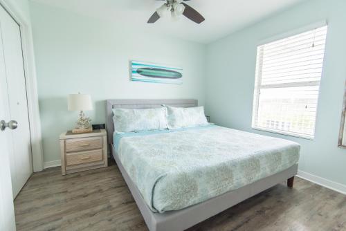 a white bedroom with a bed and a window at Grand Beach Resort Unit 313 in Gulf Shores
