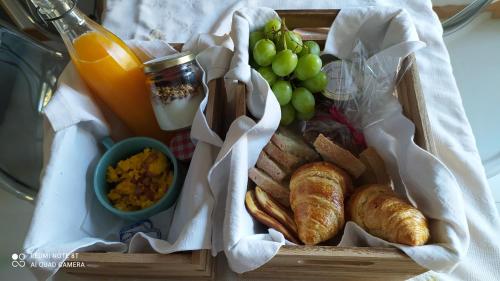 Una bandeja de comida con pan y uvas y una bebida. en Casas Martainha, en Sernancelhe