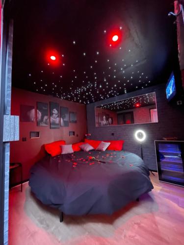 ein Schlafzimmer mit einem großen Bett mit roten Lichtern an der Decke in der Unterkunft Cosyroom25 in Besançon
