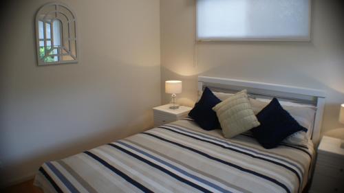 a bedroom with a bed with pillows and a mirror at Tinaroo Sunset Retreat in Barrine