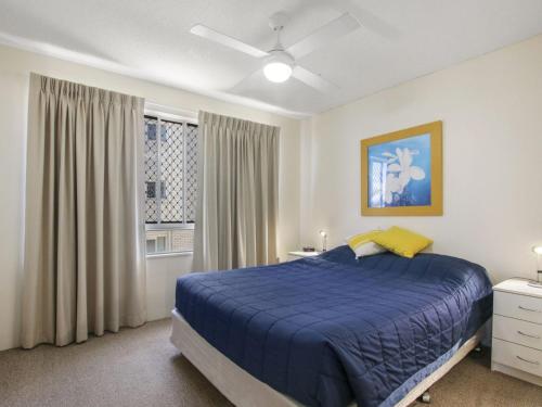 a bedroom with a blue bed and a window at Cheltenham Apartments Unit 11 40 King St in Caloundra