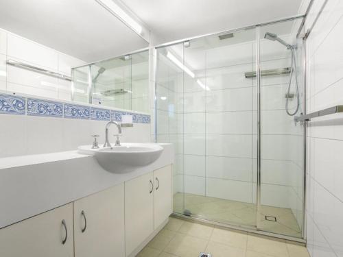 a bathroom with a sink and a glass shower at Cheltenham Apartments Unit 11 40 King St in Caloundra