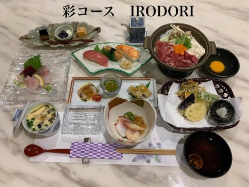 a table topped with plates of food and chopsticks at Yado Hanasaku in Tateyama