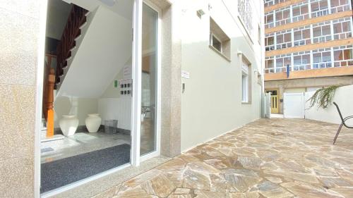 un patio vacío de un edificio con puerta de cristal en Apartamentos Pantón Ribeira Sacra, en Ferreira