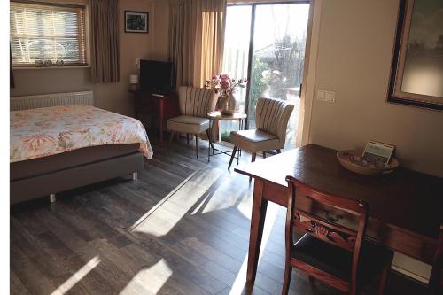 a bedroom with a bed and a table and chairs at De Galeriet Giethoorn in Giethoorn