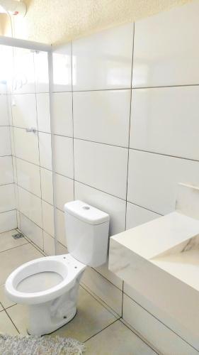 a white bathroom with a toilet and a sink at Belo quinto Styles pousada in Brotas