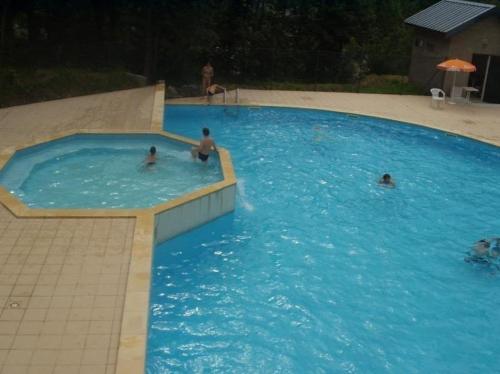 un groupe de personnes se baignant dans une grande piscine dans l'établissement STUDIO BAREGES- 1 pièce location pour 2 personnes, Station ski BAREGES-LA MONGIE, à Barèges