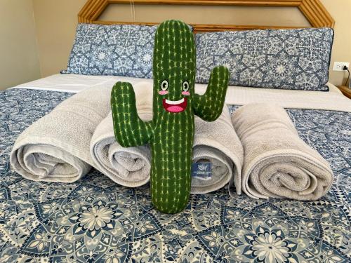 a stuffed cactus sitting on a bed with towels at LiCe Garden Aruba in Paradera