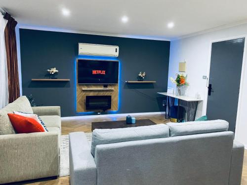 a living room with a couch and a tv at Flamingo Rentals - Modern 2-bed unit with BBQ & SPA ideal for holiday and business travel in Mildura