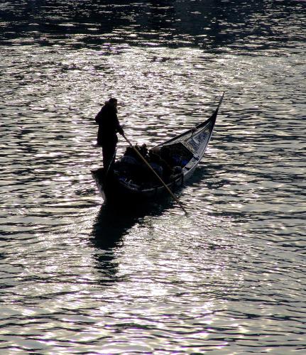 a man is rowing a boat in the water at Ca' Angeli in Venice