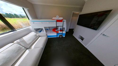 a small room with a bed and a large window at Ohakune Solar on Snowmass in Ohakune