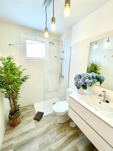 a white bathroom with a toilet and a sink at Luxury Beach Apartment Nasa in Playa Honda