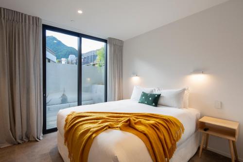 een slaapkamer met een groot bed en een groot raam bij The Hill Residence in Queenstown