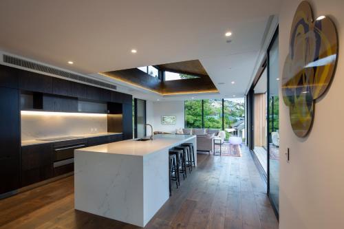 een open keuken met een wit eiland in een huis bij The Hill Residence in Queenstown