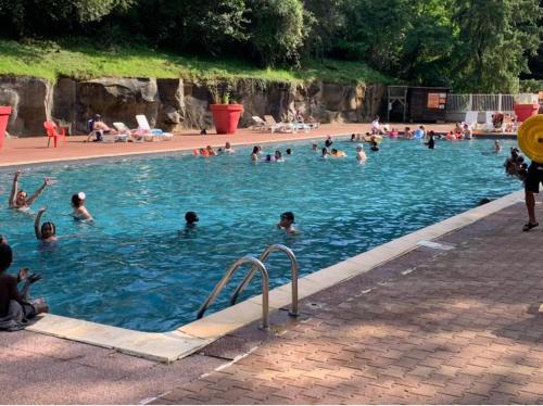 a group of people swimming in a swimming pool at camping parc des roches in Souzy-la-Briche