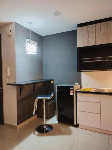 a kitchen with a bar stool and a black refrigerator at Urban360 Pool view with Netflix and wifi in Batu Caves